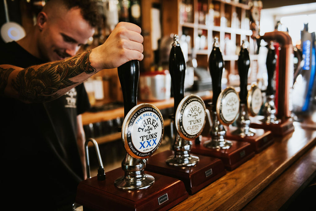 barman pulling pint of three tuns brewery beer pub shropshire