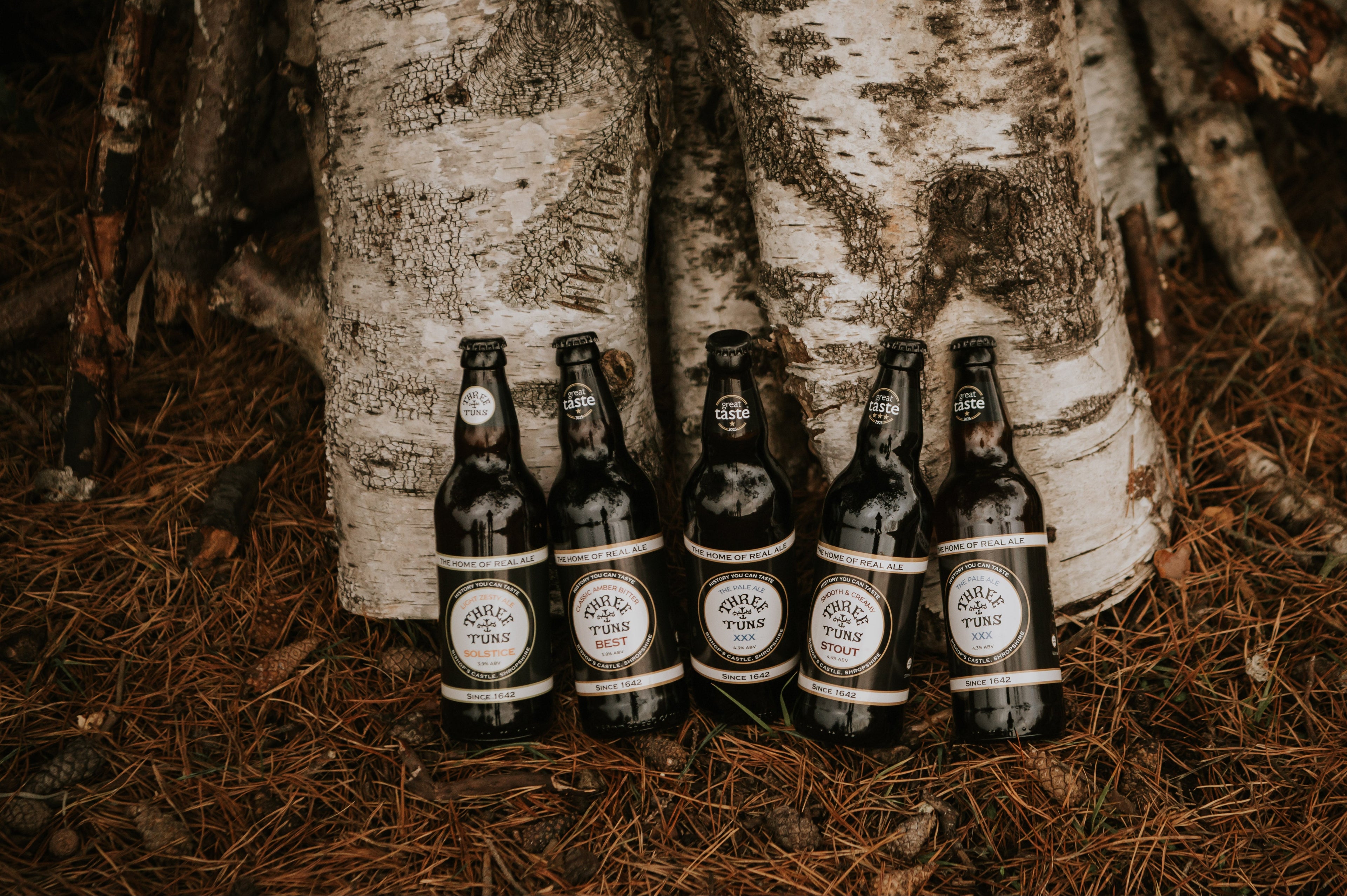 five bottles of three tuns brewery beer in shropshire woodland